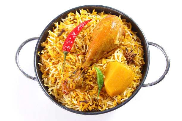 Delicious spicy chicken biryani in traditional bowl on White background, Indian or Pakistani famous masala rice food. Potato and meat are main ingredients of this recipe | Best Ramadan iftar meal.