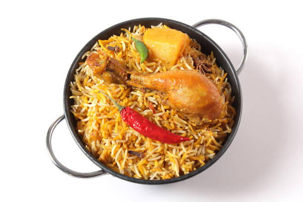 Delicious spicy chicken biryani in traditional bowl on White background, Indian or Pakistani famous masala rice food. Potato and meat are main ingredients of this recipe | Best Ramadan iftar meal.