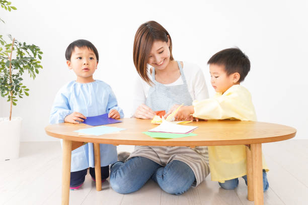 children and teachers make origami in kindergarten - preschooler child playing latin american and hispanic ethnicity imagens e fotografias de stock