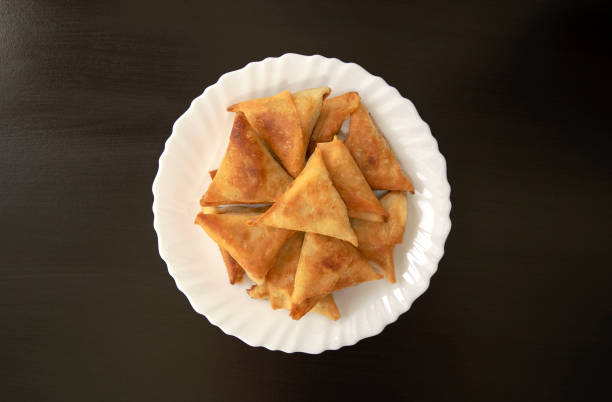 Triangular arabic chicken samosa on dark wooden background