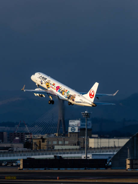 Take Off from Osaka International Airport Osaka International Airport January, 21 - 2020:J - Air (one of JAL group) Embraer ERJ 190 airplane just take off from Osaka International Airport. This aircraft painted in Minion (Universal Studios Japan) livery. konohana ward photos stock pictures, royalty-free photos & images
