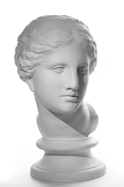 Photo of Gypsum copy of ancient statue Venus head isolated on white background. Plaster sculpture woman face.