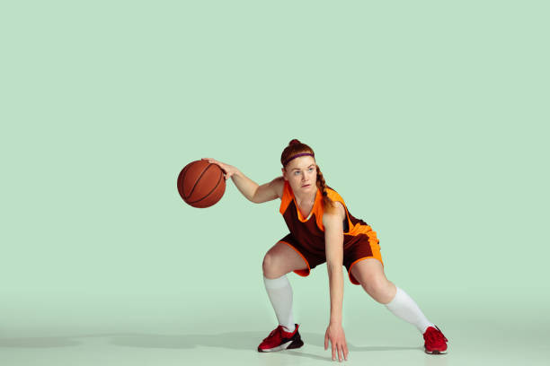 istock Young caucasian female basketball player against mint colored studio background 1224830321