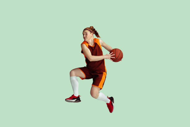 istock Young caucasian female basketball player against mint colored studio background 1224830332