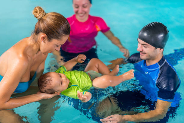 istock Mother with baby boy and instructors on swimming class 1224834373