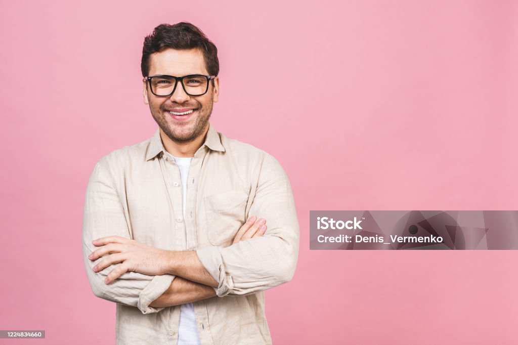 A portrait of young smiling handsome business man in casual shirt isolated on pink background. Teacher Stock Photo