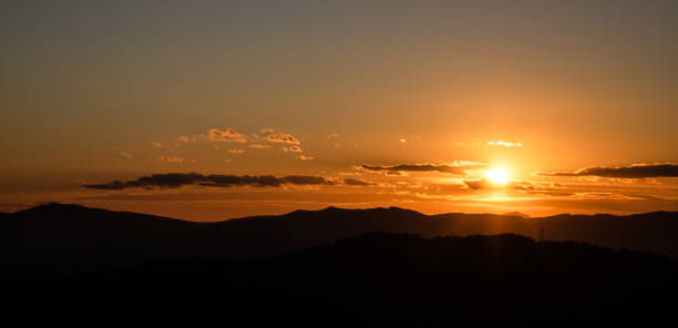 istock Beautiful sunset with sun rays with hills silhouette 1224835714