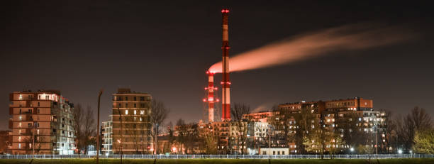 nocny widok na dym wydobywający się z komina nad blokami mieszkalnymi w mieście. - wroclaw traffic night flowing zdjęcia i obrazy z banku zdjęć