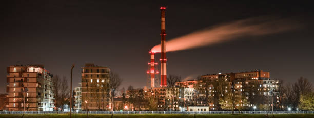 night view of the smoke coming out of the chimney over apartment blocks in the city. - wroclaw traffic night flowing imagens e fotografias de stock