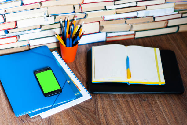 istock Textbook, notebook, mobile phone smartphone, stack of books. Home distance education background, stay home concept 1224836643