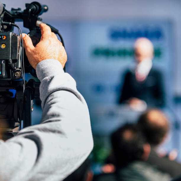istock Media Event. Cameraman Recording Speaker On Stage 1224837668