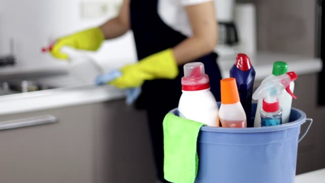 Cleaning supplies in bucket, Woman cleaning on background,