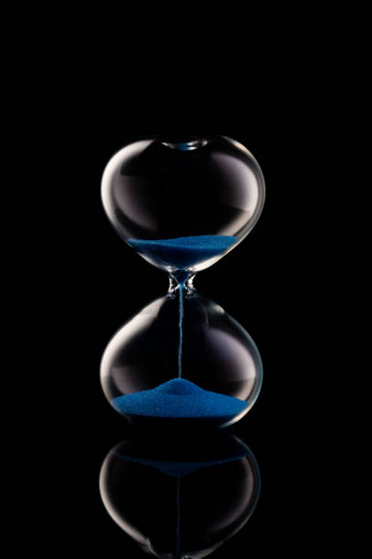istock Blue sand hourglass on black 1224839559