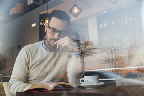 Man reading a book in coffee shop