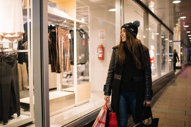 istock Young woman looking at the clothes through window 1224839928