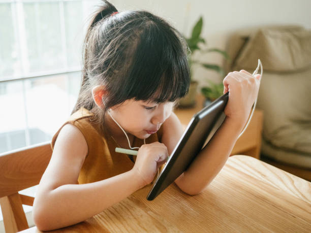 istock Little girl doing her homework with digital tablet. 1224840849