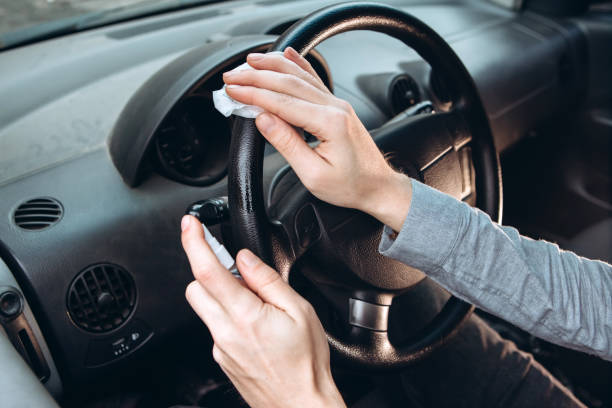 istock guy uses a sanitizer while driving a car. Precautions during the coronavirus epidemic. Fuse from COVID-19. A man in a medical mask in a car. 1224842601