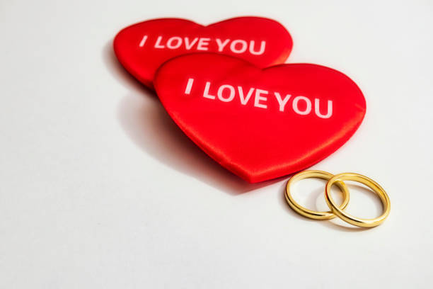 red hearts and wedding rings on a white background