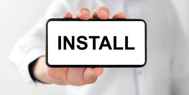 istock INSTALL word text on phone screen in male hand with blurring man on background. Technology and internet concept 1224849736