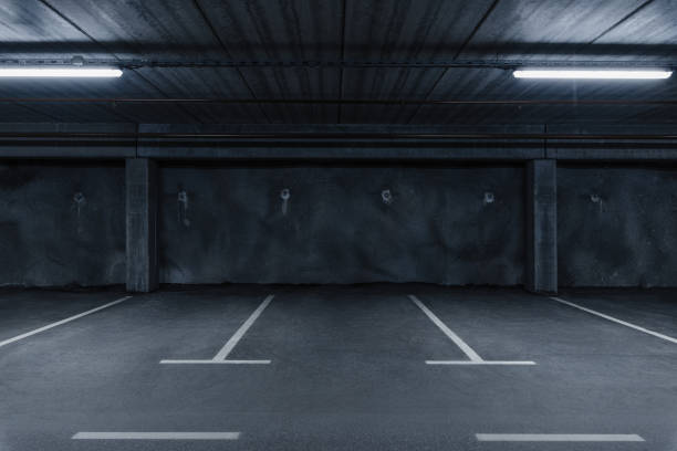 Car parking space Sci fi looking dark and moody underground parking lot with fluorescent lights on.  Concrete wall industrial style photos stock pictures, royalty-free photos & images