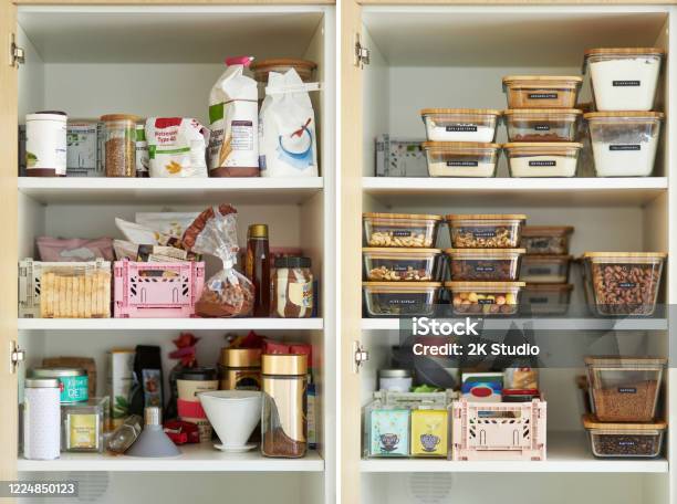 A Middleaged Woman Tidies Up Her Cupboard In The Kitchen And Reorganizes Everything Stock Photo - Download Image Now