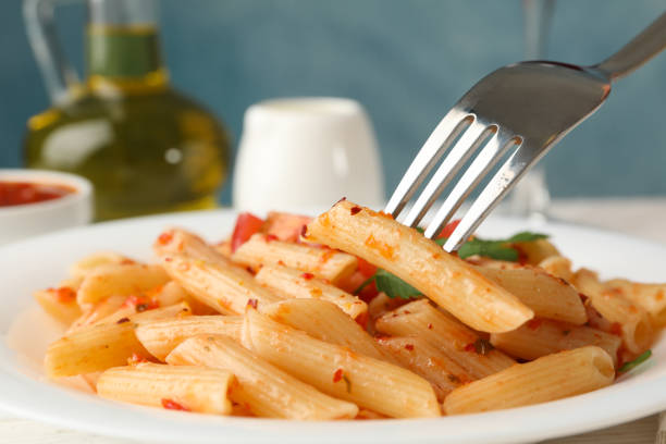 plate of italian pasta penne with bolognese sauce and grated parmesan