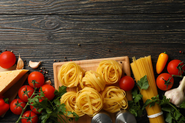 istock Composition with pasta and ingredients for cooking on wooden background, top view 1224853843