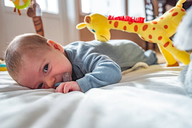 Cute baby boy laying down in baby gym. stock photo