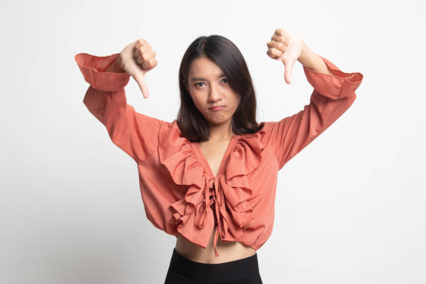 istock Unhappy Asian girl show thumbs down with both hands . 1224854898