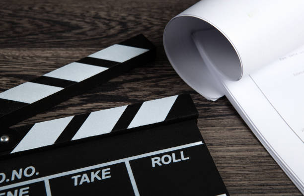 istock black movie clapper with a script sheets on a wooden table closeup 1224856753
