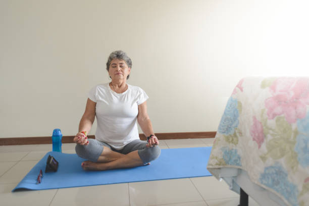 istock Senior woman meditating at home 1224857737