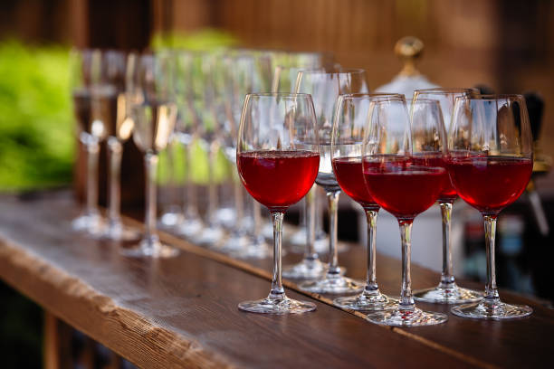 istock glasses with red wine, fruit drinks are poured into glasses, drinks are poured into glasses, clear glass is on the table 1224857795