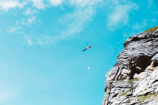 istock Red helicopter carrying baggage in Swiss Alps mountains 1224859467