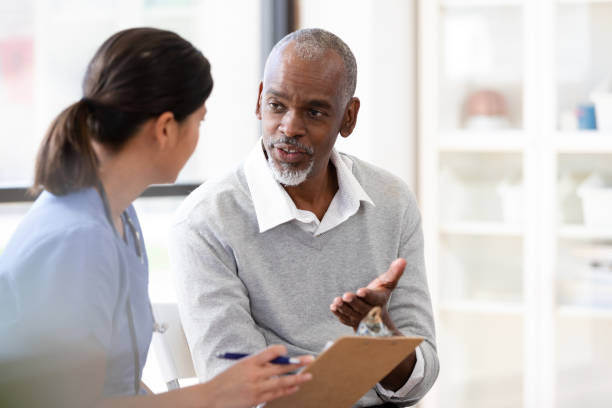 istock Senior man gestures while speaking to unrecognizable mid adult nurse 1224859645