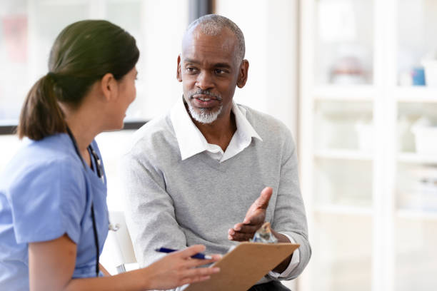istock Senior man gestures as he answers question for nurse 1224859657