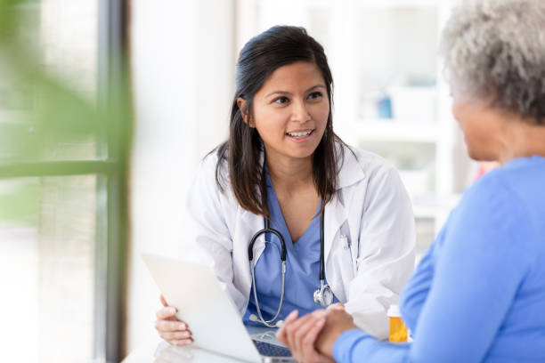 le patient féminin écoute attentivement au docteur féminin adulte moyen - primary care photos et images de collection