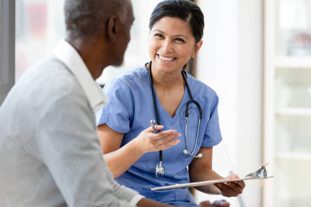 istock Female nurse gestures and smiles while questioning senior patient 1224859661