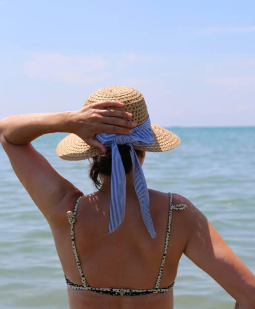 istock slender young woman with straw hat while looking at the sea 1224864310