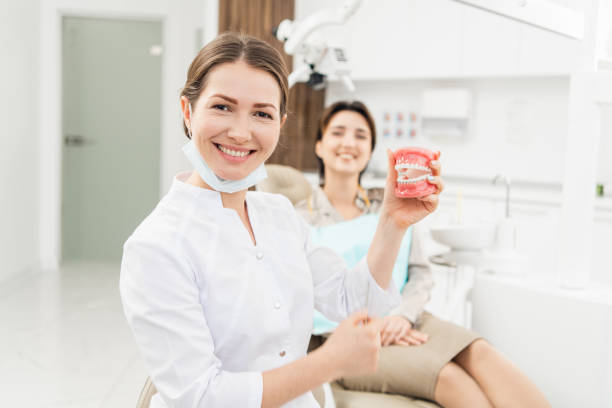 Female Dentist with denture in the dentistry's office stock photo