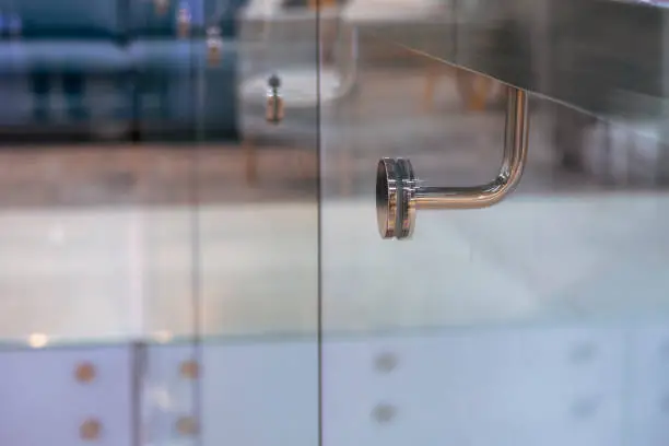 Stainless steel handrail support and glass wall in modern building. Selective focus. Business background.