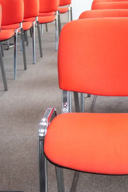 Red chairs in a meeting room. Empty seats in auditorium. Selective focus. Nobody.