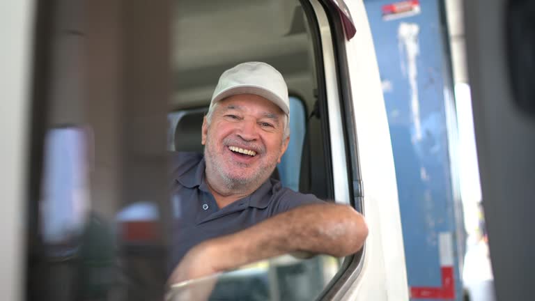 Portrait of a senior male truck driver sitting in cab