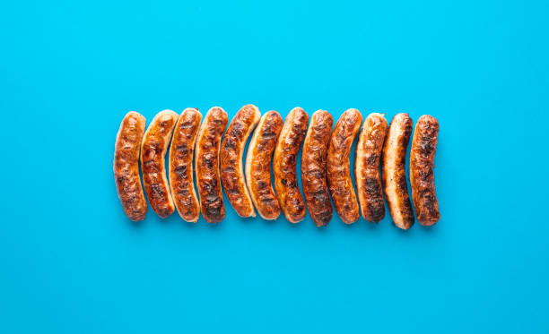 Grilled nuremberger bratwurst. German sausages top view Above view with grilled german sausages, alligned on a blue background. Authentic grilled nuremberger bratwurst bratwurst stock pictures, royalty-free photos & images