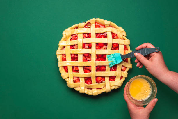 イチゴのタルトを作る。パイを卵黄でグリース。 - washing fruit preparing food strawberry ストックフォトと画像