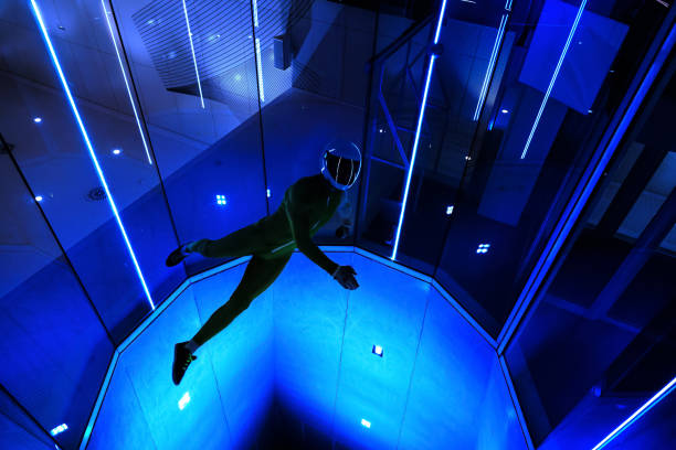 A man flier doing stunts in an indoor wind tunnel