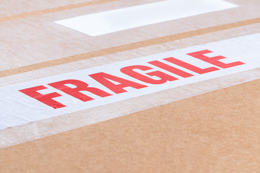 Fragile labeling tape closeup on cardboard packaging