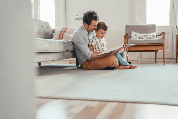 familie liest ein buch - son love father childhood stock-fotos und bilder