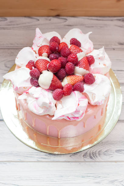 istock Pink cheese cake with melted chocolate, meringues, fresh raspberries and strawberries. 1224881274