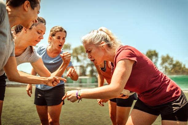 Female soccer team shouting and cheering on field