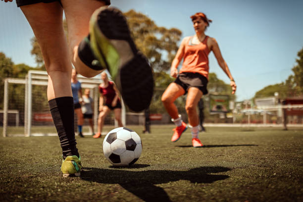 mittlere erwachsene frauen, die fußball spielen - soccer skill soccer ball kicking stock-fotos und bilder